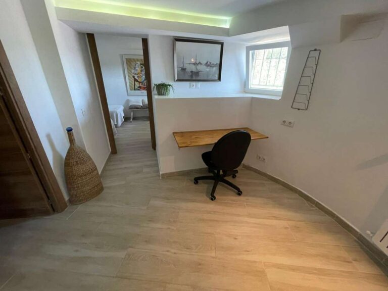 Office space with desk and natural light inside a refurbished villa with three independent apartments in Canuta, Calpe.