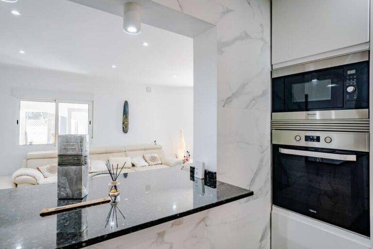 Open kitchen detail with breakfast bar and integrated oven inside a renovated Mediterranean villa in La Cometa, Calpe.