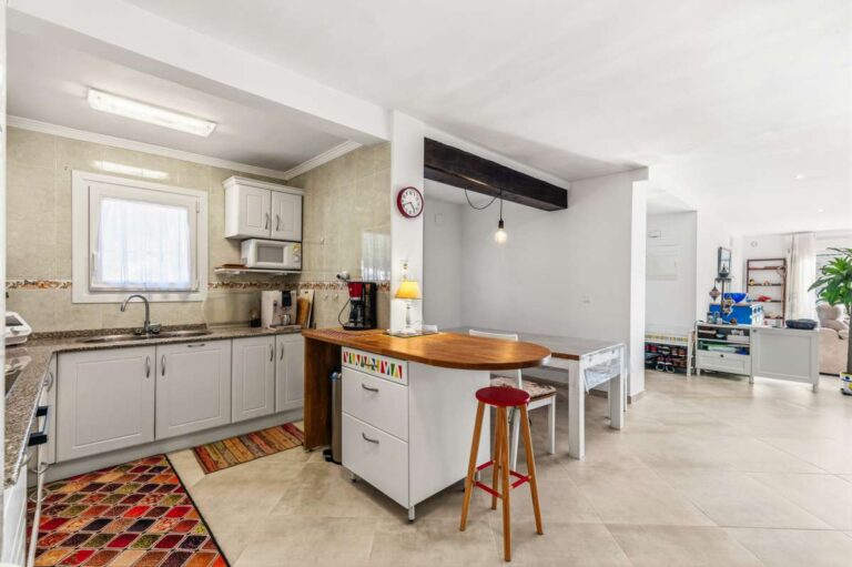 Open kitchen with breakfast bar connected to the living area inside a contemporary villa for sale in Calpe.