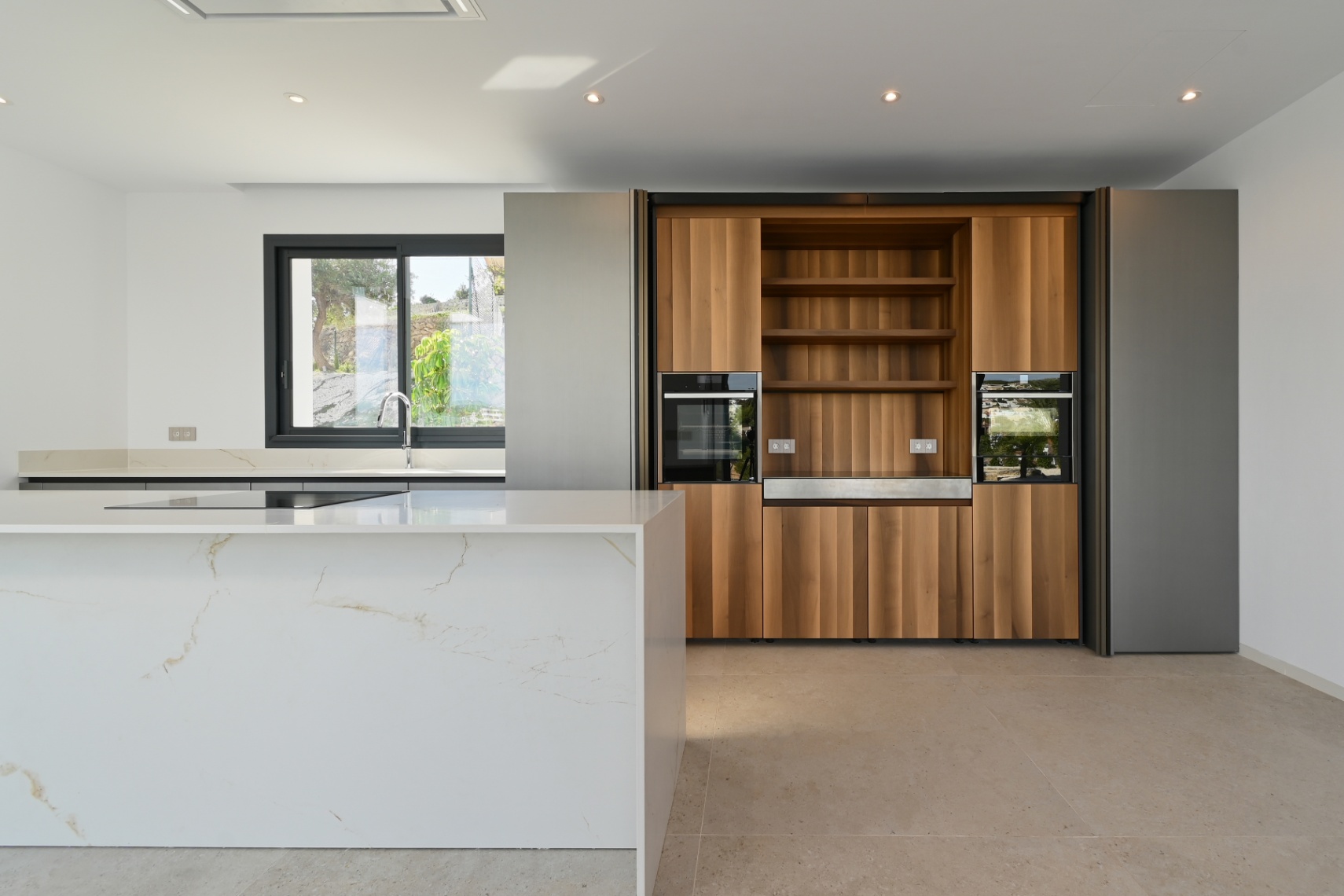Open kitchen with island and wood cabinetry at luxury villa in Benissa