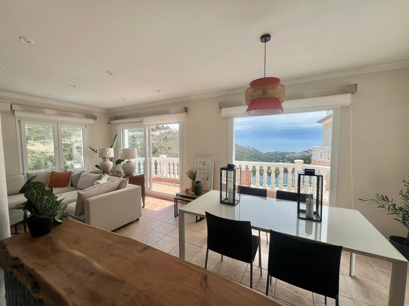 Open living and dining area with sea views at modern villa in Moraira