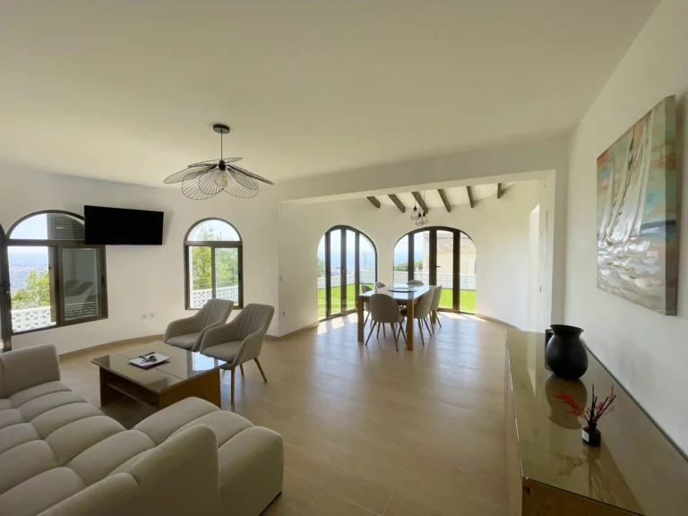 Open living and dining room with arched windows at villa in Oltamar, Calpe