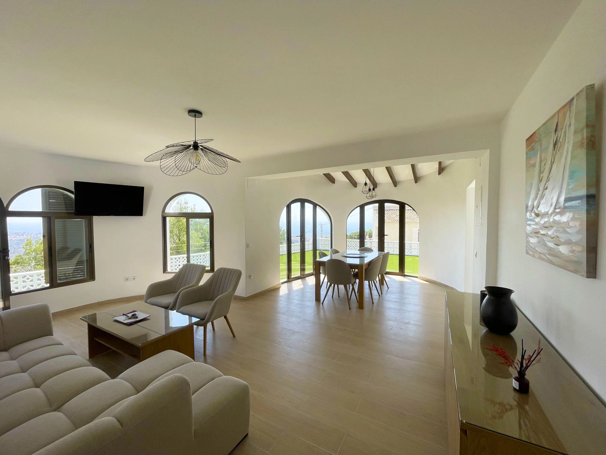 Open living and dining room with arched windows at villa in Oltamar, Calpe