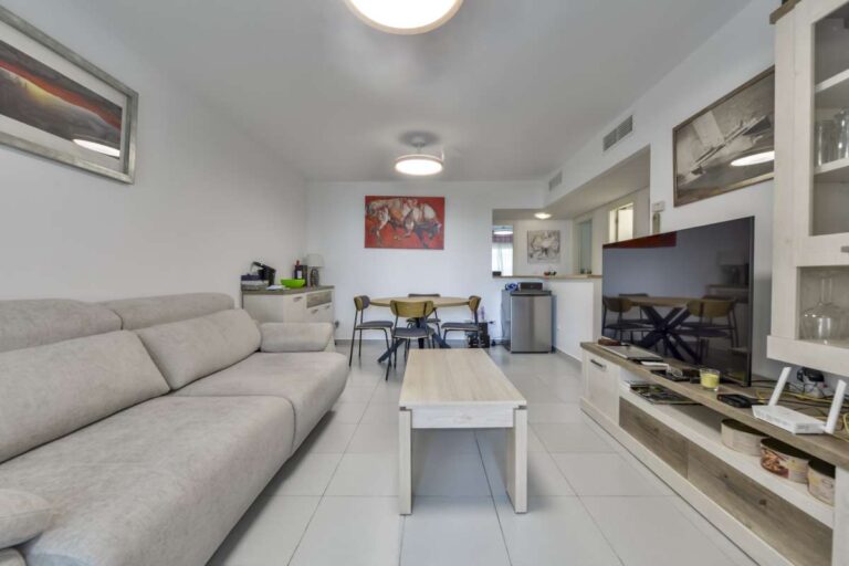 Open living and dining space inside a frontline La Fossa apartment in Calpe with sofa seating, dining area and fitted storage