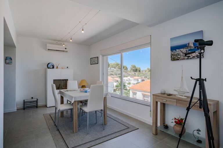 Open living and dining space inside a modern villa in Calpe with large windows and natural light