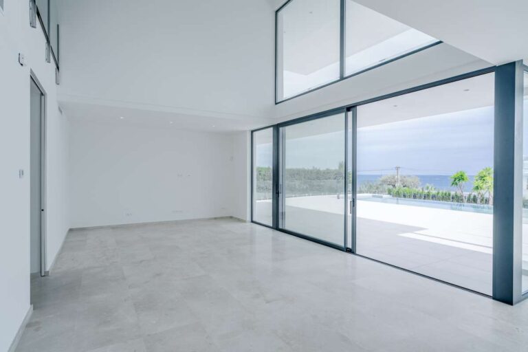 Open living area inside a modern villa in La Calalga, Calpe with floor-to-ceiling glass doors, terrace access and sea views
