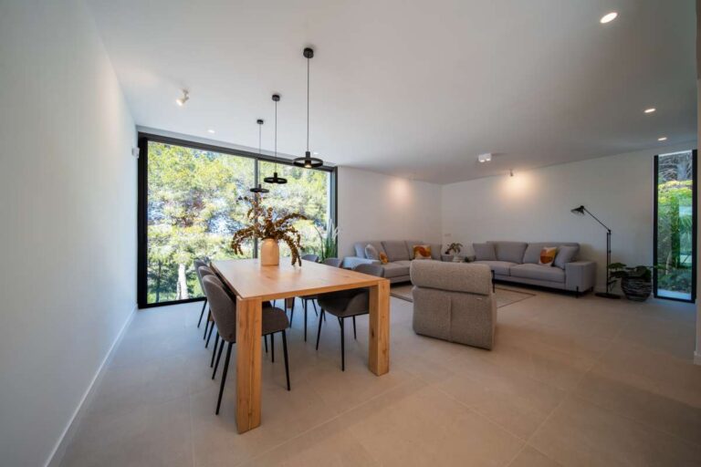 Open-plan dining and living area inside a new-build luxury villa in Moraira with modern furniture, large windows and natural light