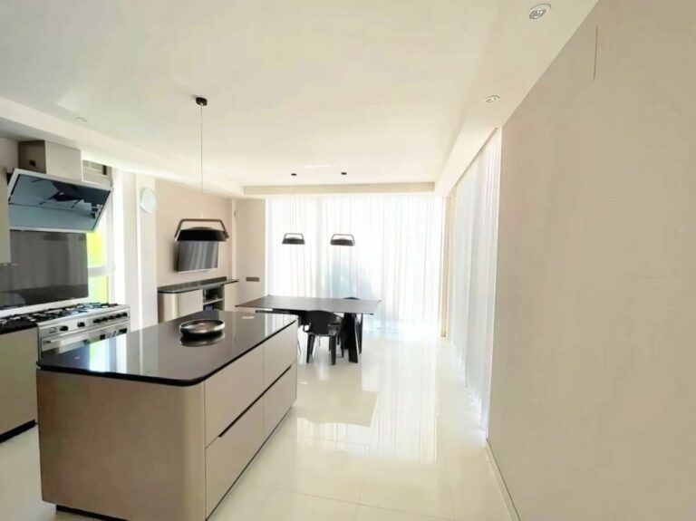 Open-plan kitchen and dining area inside a modern luxury villa in La Calalga, Calpe with central island, integrated appliances and bright interior finish