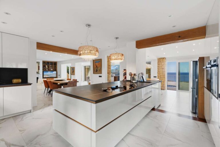 Open-plan kitchen and living area inside a premium coastal villa on the Benissa Costa with central island, sea views and bright modern finish