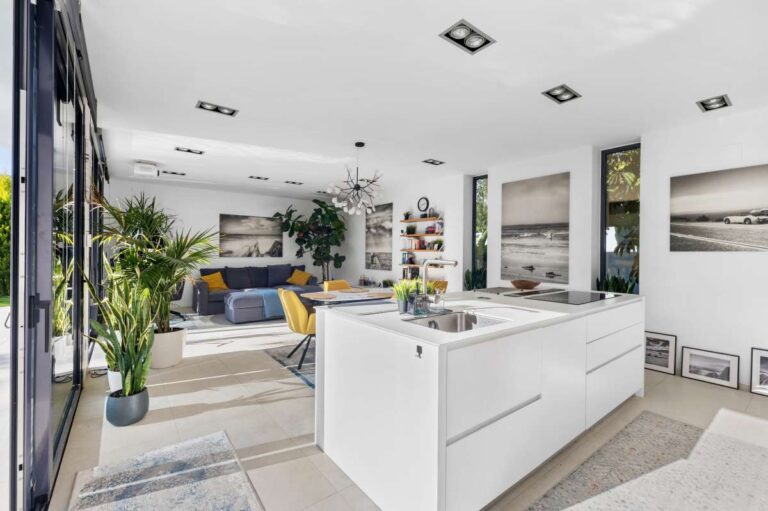 Open-plan kitchen and living area with direct terrace access inside a modern oasis villa near Arenal-Bol Beach in Calpe.