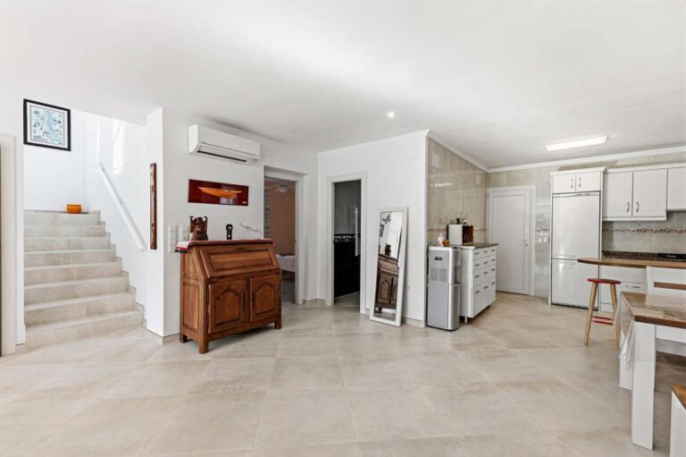 Open-plan kitchen area with staircase and bright interior inside a contemporary villa in Calpe with private pool.