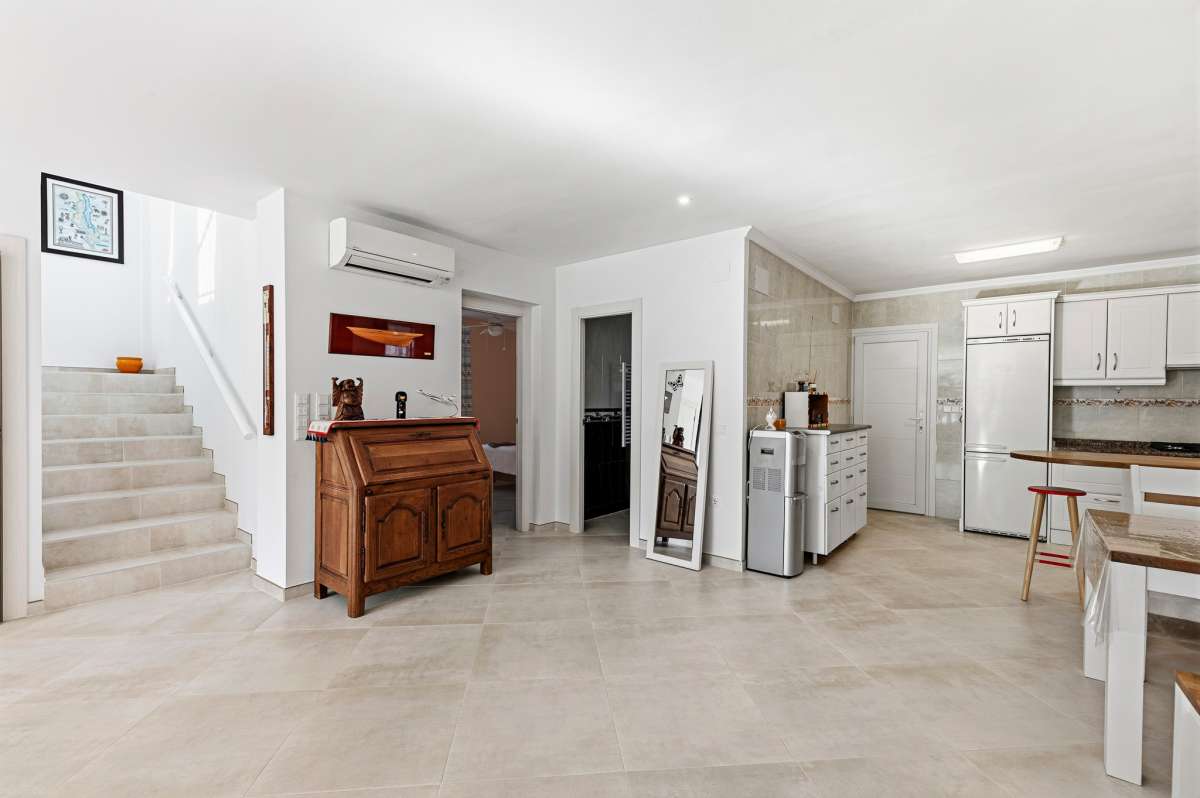 Open-plan kitchen area with staircase and bright interior inside a contemporary villa in Calpe with private pool.