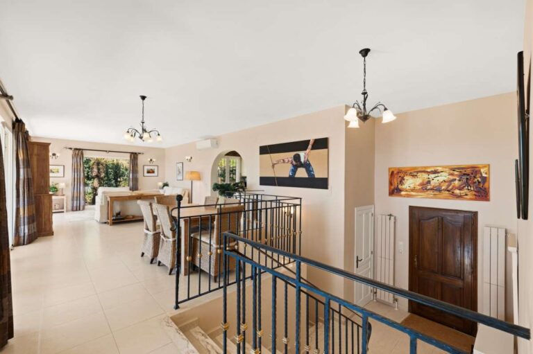 Open-plan living and dining area inside an elegant Mediterranean villa in Altea Hills with staircase, dining space and terrace access