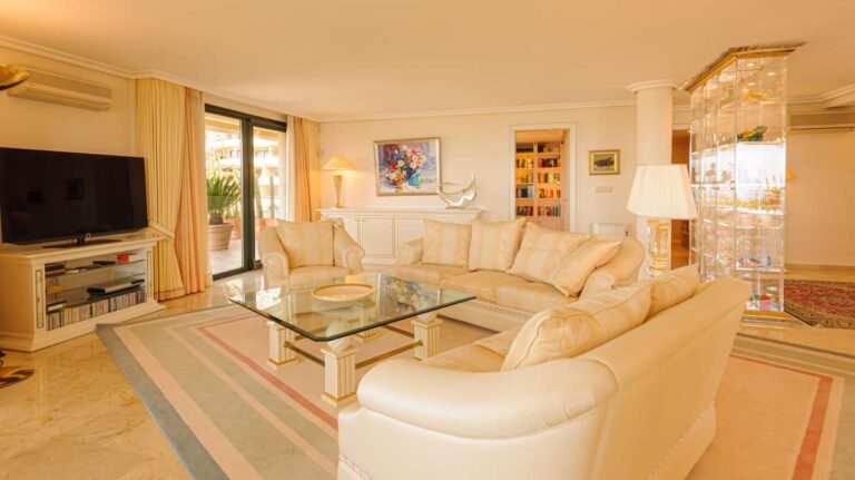 Open-plan living area inside a luxury apartment in Sierra de Altea with cream sofas, marble flooring, large windows and bright interior finish