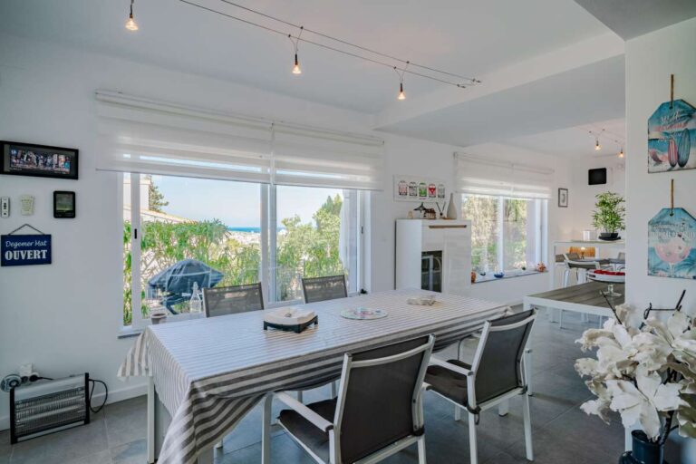 Open-plan living area inside a modern villa in Calpe with dining space, large windows and bright interior design