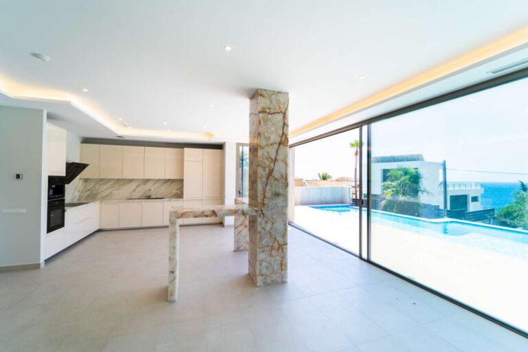 Offener Wohnbereich in einer neu gebauten Luxusvilla in der Nähe des Yachthafens Puerto Blanco in Calpe mit großen Fenstern, Meerblick und moderner Küche