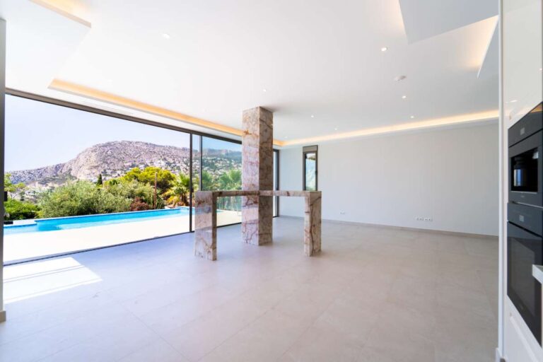 Offener Wohnbereich in einer neu gebauten Luxusvilla in der Nähe des Yachthafens Puerto Blanco in Calpe mit Blick auf den Pool, die Berge und große Fenster