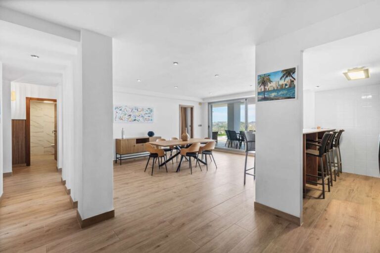 Open-plan lower level with dining area and terrace access inside a modern spacious villa in Calpe.
