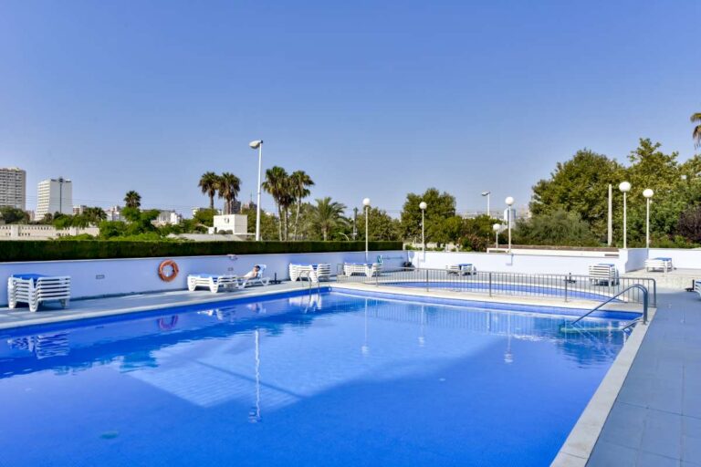 Outdoor communal swimming pool at a beachfront apartment building in La Fossa, Calpe with terrace area and sun loungers