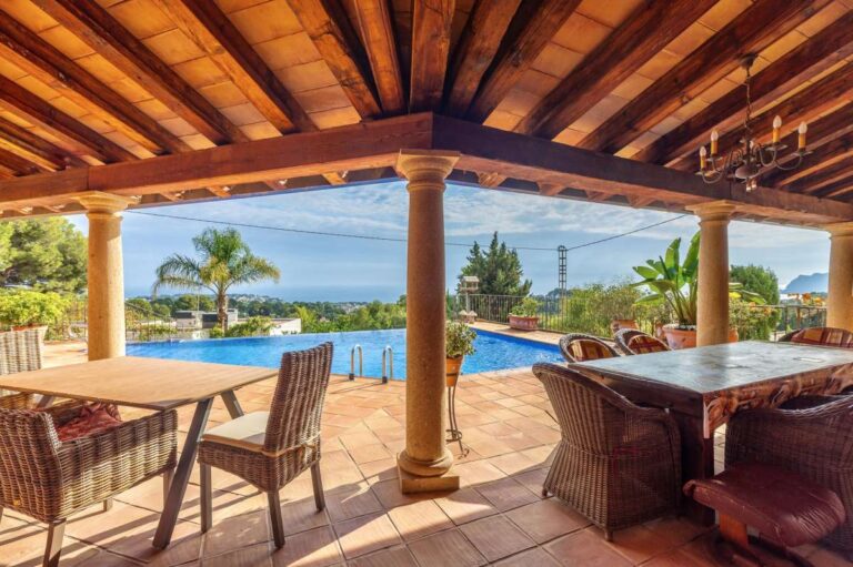 Outdoor dining terrace at a finca-style villa in Benissa Costa with wooden beams, pool views, sea views and rustic Mediterranean design