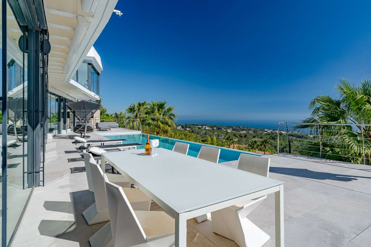 Outdoor dining terrace beside the infinity pool with panoramic sea views at a luxury villa in Gran Sol, Calpe.