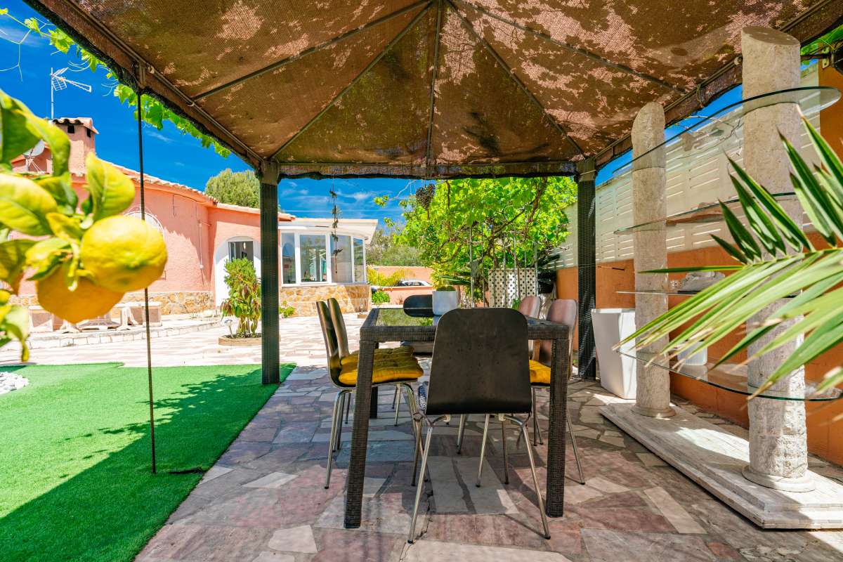 Outdoor dining terrace under a pergola at a renovated Mediterranean villa in La Cometa, Calpe.