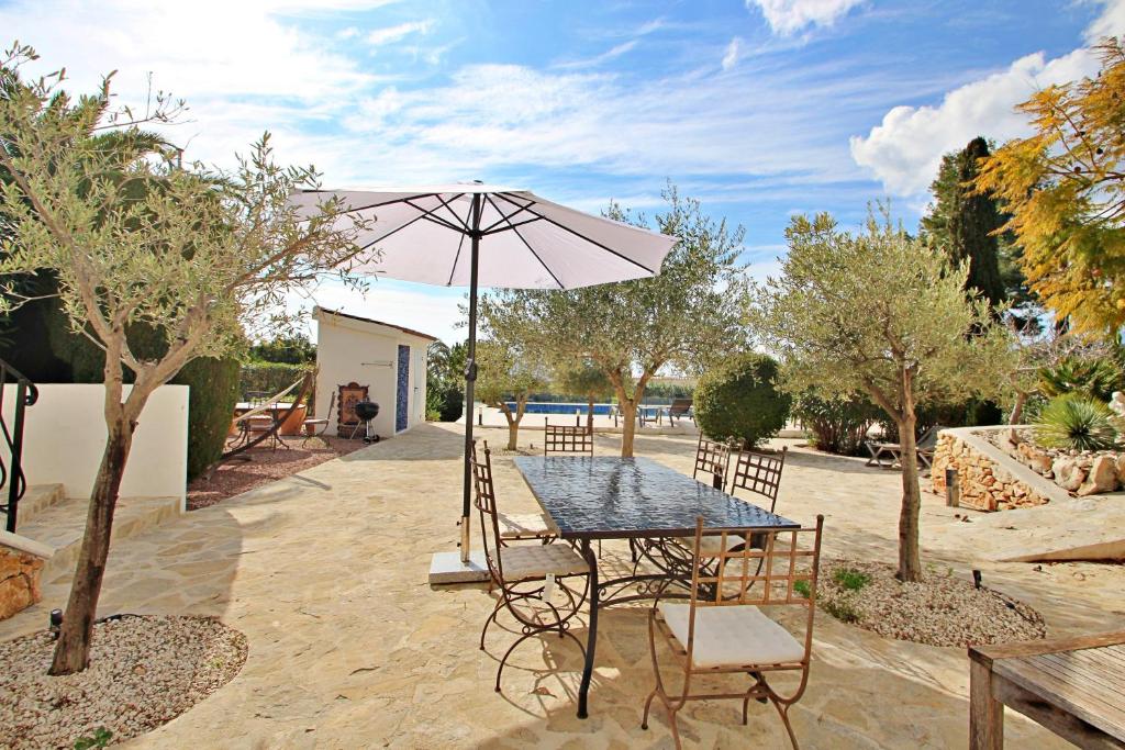 Outdoor dining terrace with mature trees at south-facing villa in Moraira