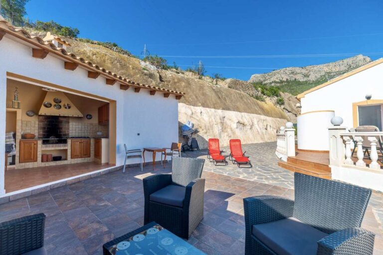 Outdoor seating area and summer kitchen on a sunny terrace at a villa in Calpe.