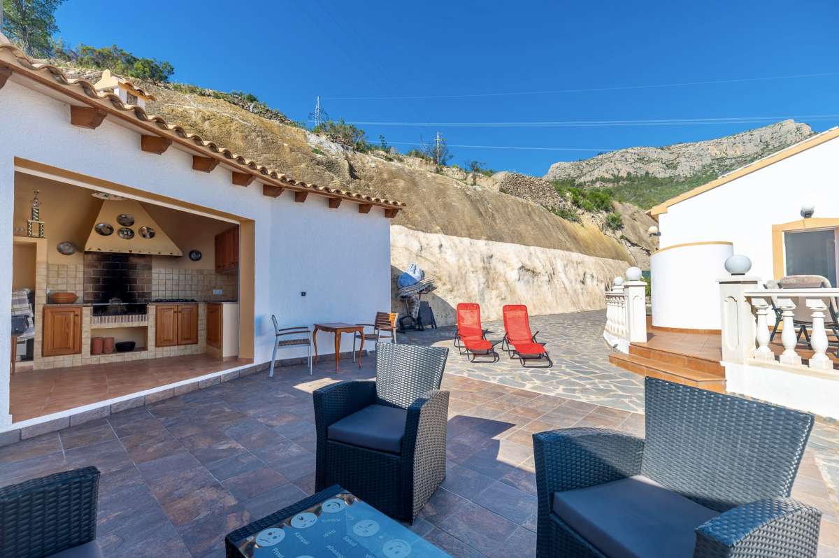Outdoor seating area and summer kitchen on a sunny terrace at a villa in Calpe.