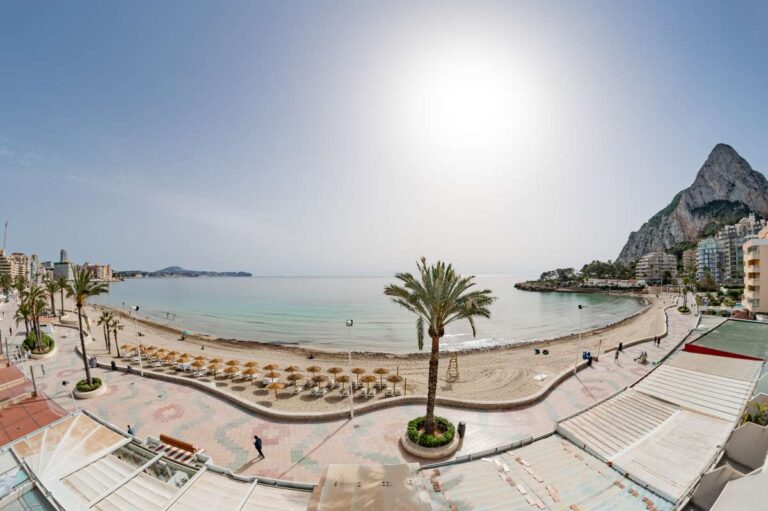 Panoramic views from a beachfront apartment by La Fossa Beach in Calpe showing the promenade, sandy beach, Mediterranean Sea and Peñón de Ifach