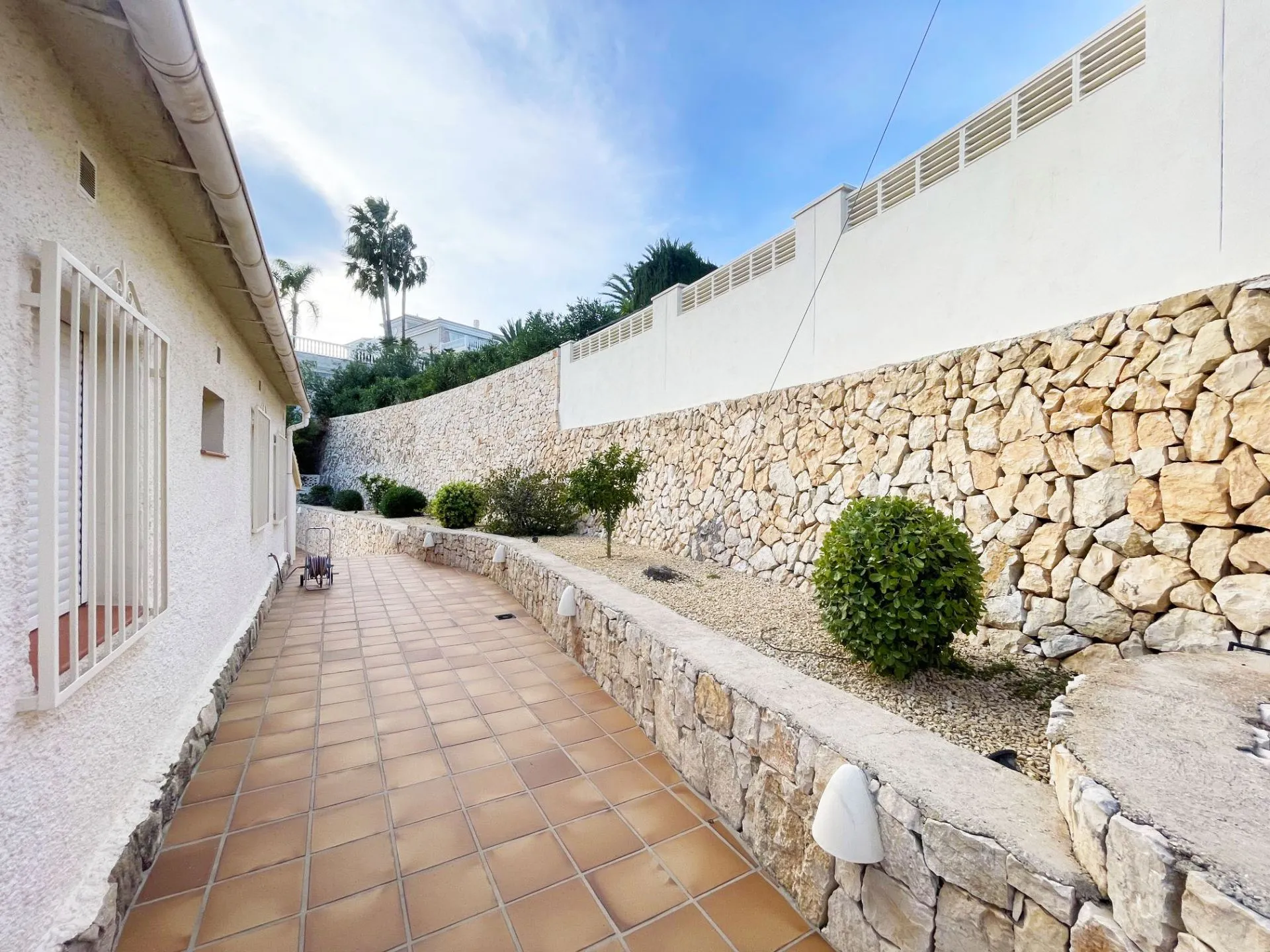 Paved side terrace and irrigated low-maintenance garden at renovated villa in Calpe