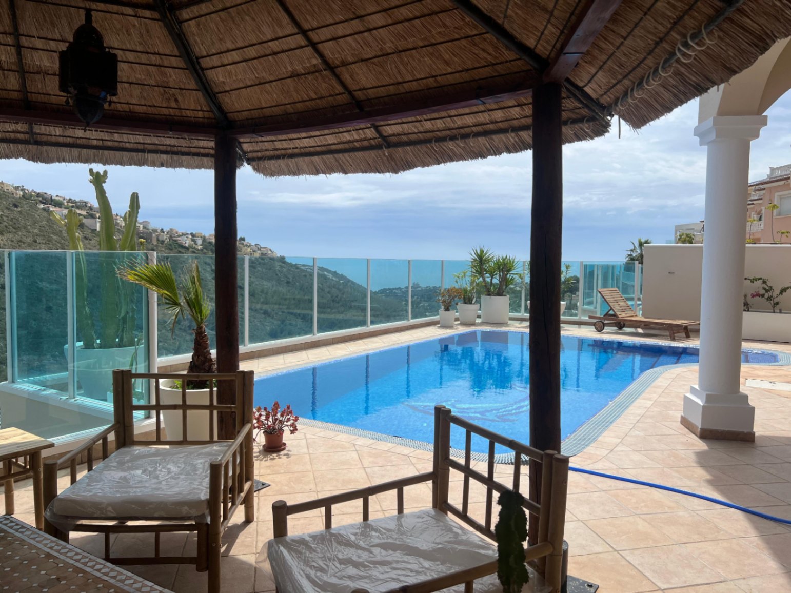 Pergola seating area beside pool at modern villa in Moraira