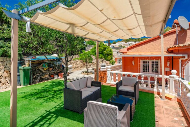 Pergola seating area with artificial grass and outdoor lounge furniture at a renovated Mediterranean villa in La Cometa, Calpe.