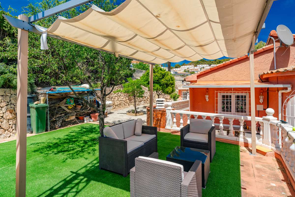 Pergola seating area with artificial grass and outdoor lounge furniture at a renovated Mediterranean villa in La Cometa, Calpe.