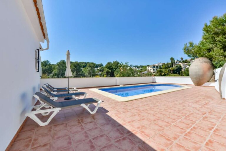 Pool terrace at a charming Benissa Coast villa with private swimming pool, sun loungers, tiled terrace and garden views