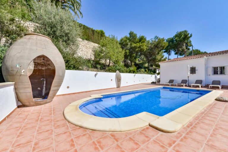 Pool terrace at a charming Benissa Coast villa with private swimming pool, unique outdoor shower, tiled terrace and garden surroundings