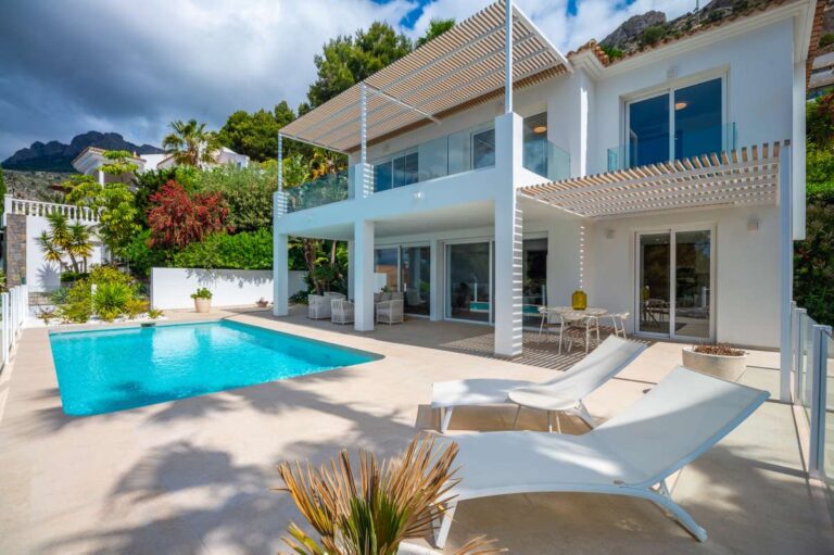Pool terrace at a modern villa in Altea Hills with private swimming pool, sun loungers, glass balcony and white contemporary exterior