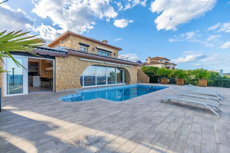 Pool terrace at a premium coastal villa on the Benissa Costa with private swimming pool, stone façade, sun loungers and sea views