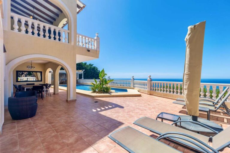 Pool terrace at an elegant Mediterranean villa in Altea Hills with sun loungers, outdoor seating and panoramic Mediterranean Sea views