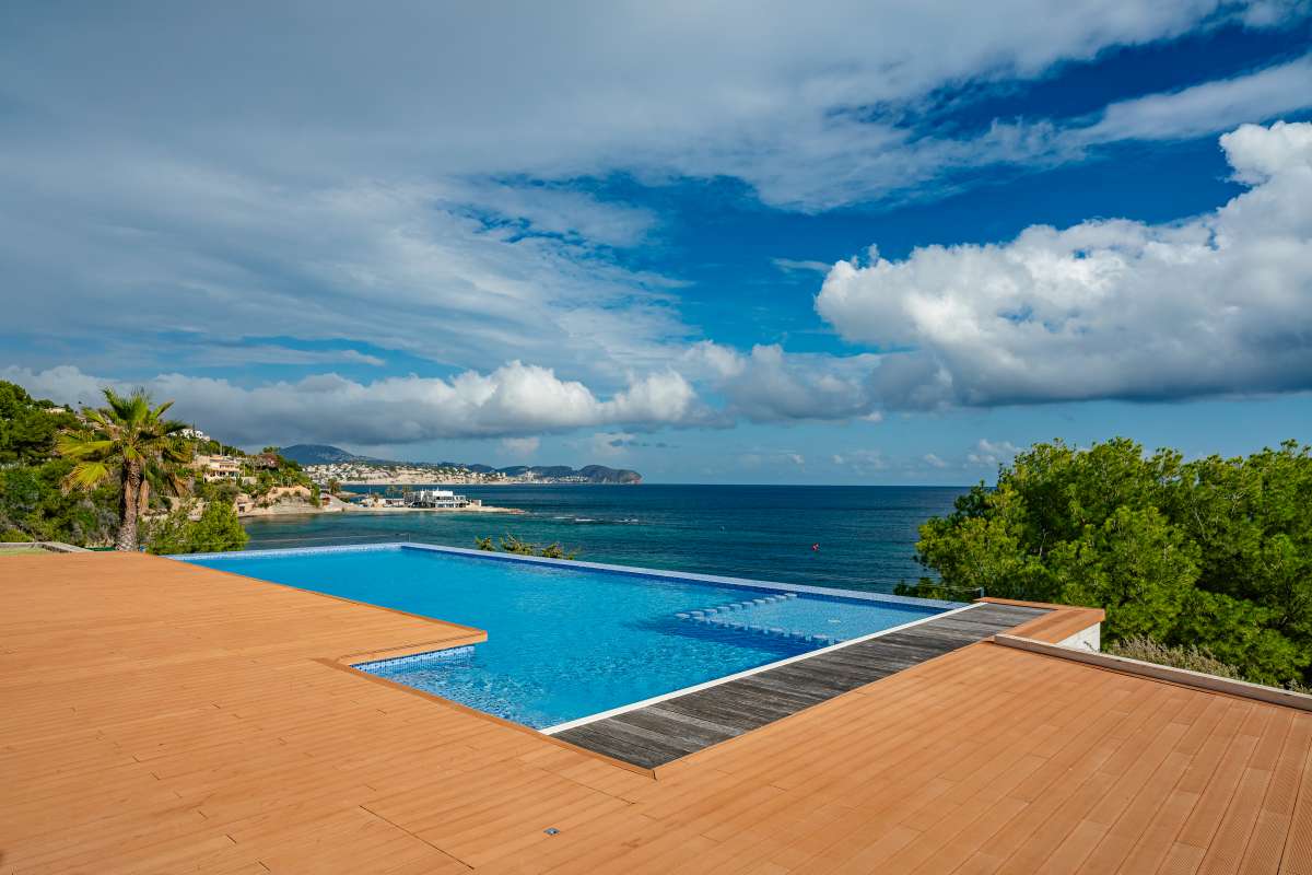 Pool terrace with infinity pool and panoramic sea views at a frontline villa in Les Bassetes.