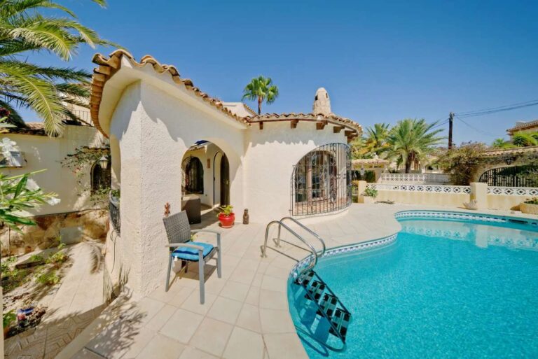 Pool terrace with Mediterranean villa exterior and traditional arched details near Puerto Blanco in Calpe.