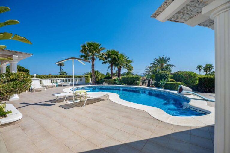 Pool terrace with sea views, sunbathing space, and outdoor seating at a villa in Calpe.