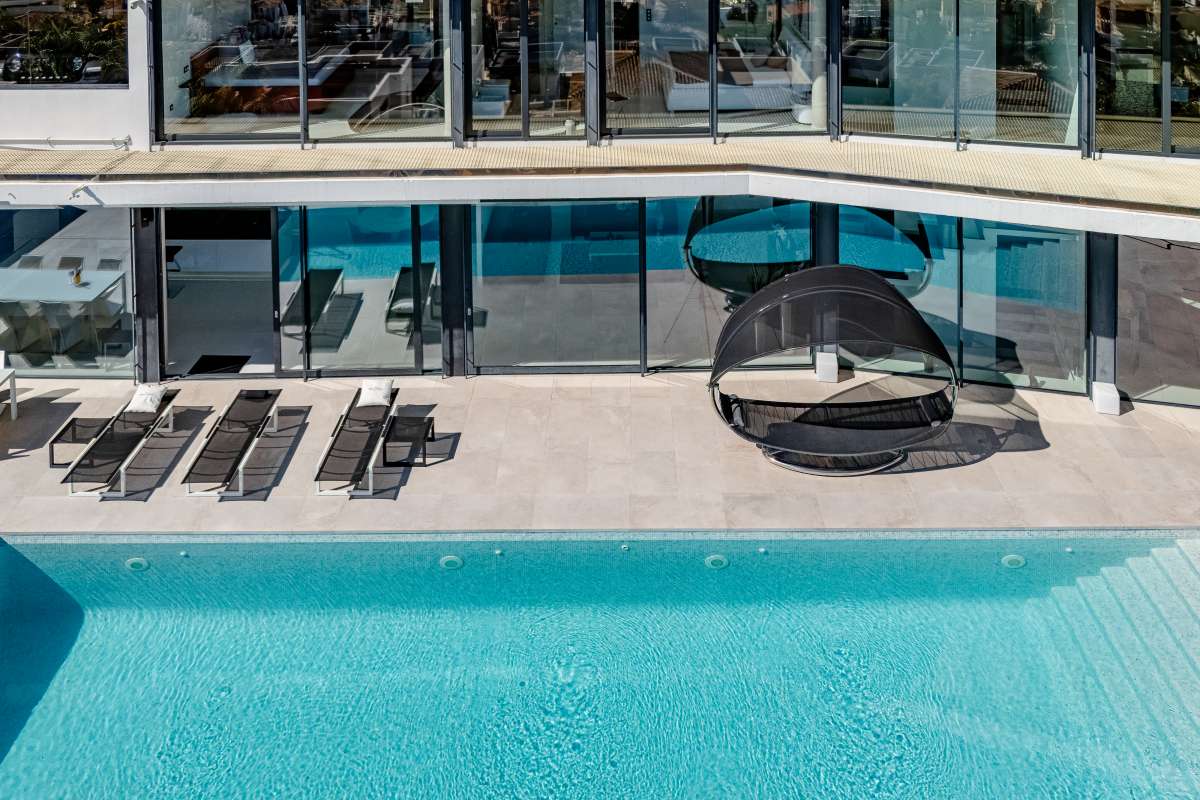 Pool terrace with sun loungers and chill-out area at a luxury modern villa in Gran Sol, Calpe.