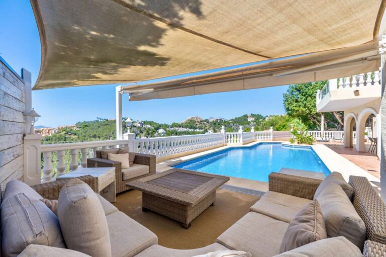 Poolside lounge area at an elegant Mediterranean villa in Altea Hills with shaded seating, private pool views and panoramic sea views