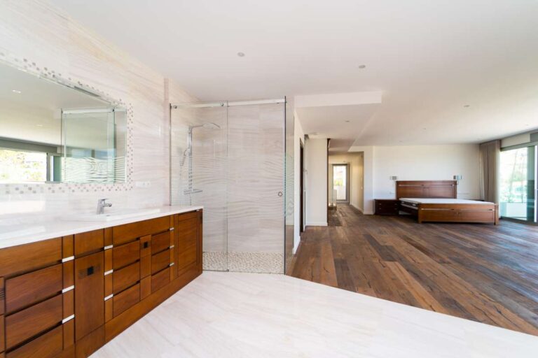 Principal en-suite inside a luxury villa in Calpe with double vanity, wood cabinetry, open bedroom access and bright contemporary finish