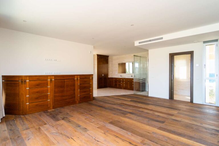 Principal suite inside a luxury villa in Calpe with wood flooring, built-in storage, en-suite access and bright modern interior