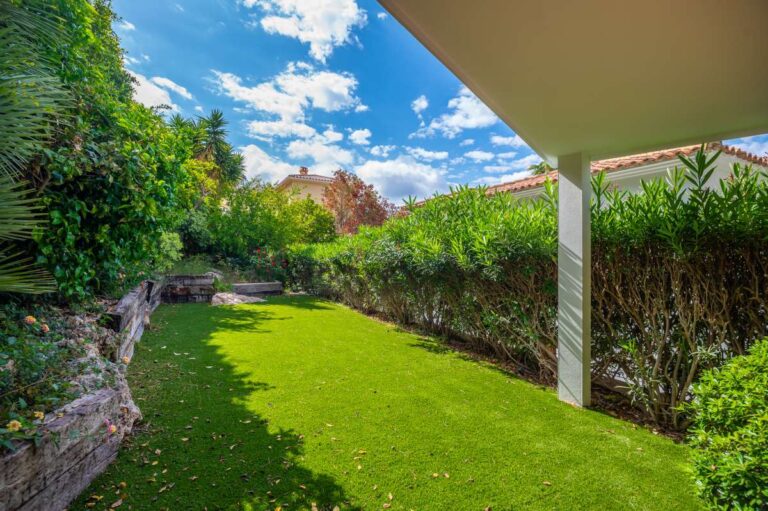 Private garden at a modern villa in Altea Hills with lawn area, hedging, shaded terrace and Mediterranean planting