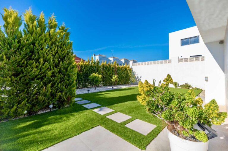 Private garden with lawn, stepping stone pathway and privacy hedging at a modern oasis villa in Calpe.