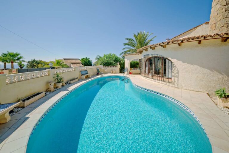 Private kidney-shaped swimming pool with terrace at a second line Mediterranean villa near Puerto Blanco in Calpe.