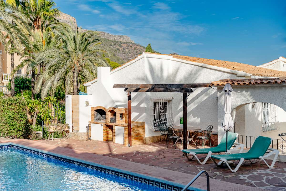 Private pool terrace with BBQ area, sun loungers and mountain surroundings at a Mediterranean villa in Maryvilla, Calpe.